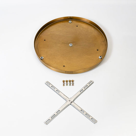 Round metal ceiling plate in warm gold finish shown with cross mounting bracket screws and hardware laid out on white background.