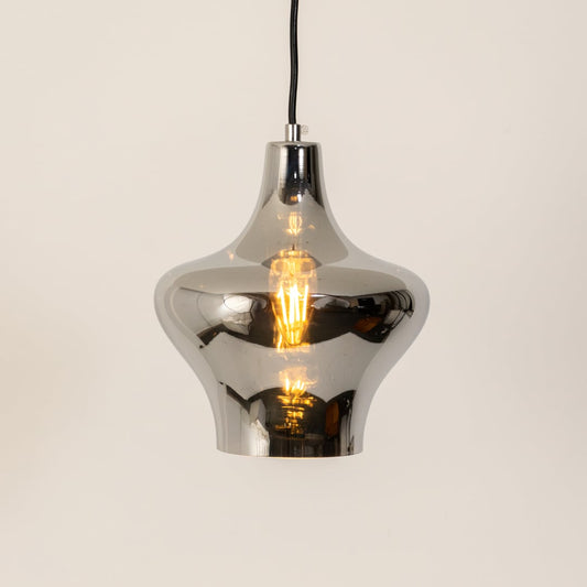 Sleek chrome pendant light glowing softly against a clean white background highlighting its modern curves and reflective metallic finish.