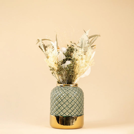 Blue ceramic vase with raised diamond pattern and metallic gold base viewed against a neutral backdrop.