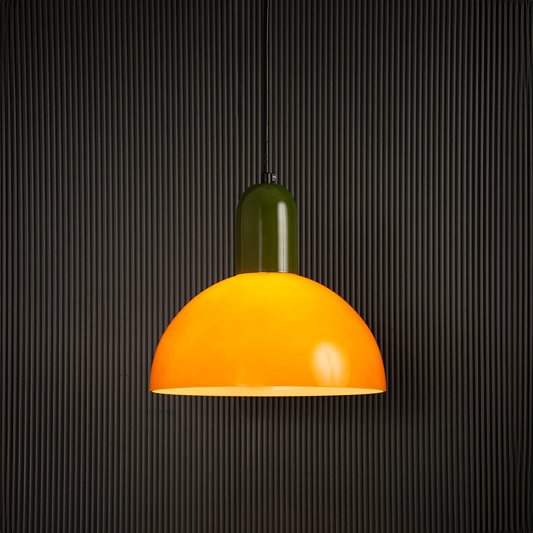 Bold orange and green pendant lamp glowing beautifully on dark background highlighting its smooth finish and lively contemporary design.