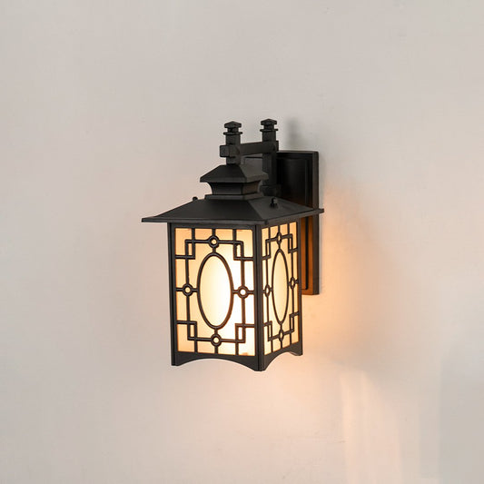 Black metal outdoor wall lantern on white background with an intricate geometric lattice frame and frosted glass panels.