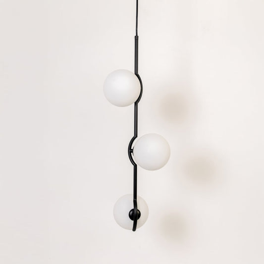 Three-globe pendant light shown turned off on a white background highlighting its frosted round shades and modern black vertical structure.