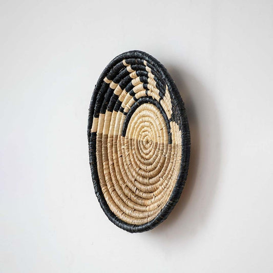 Side profile of handwoven bamboo wall plate in black beige showing texture depth and detailed woven craftsmanship.