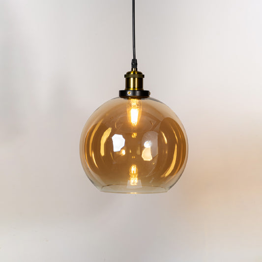 Amber glass globe pendant light with brass metal holder and contemporary design for elegant ceiling lighting decor.