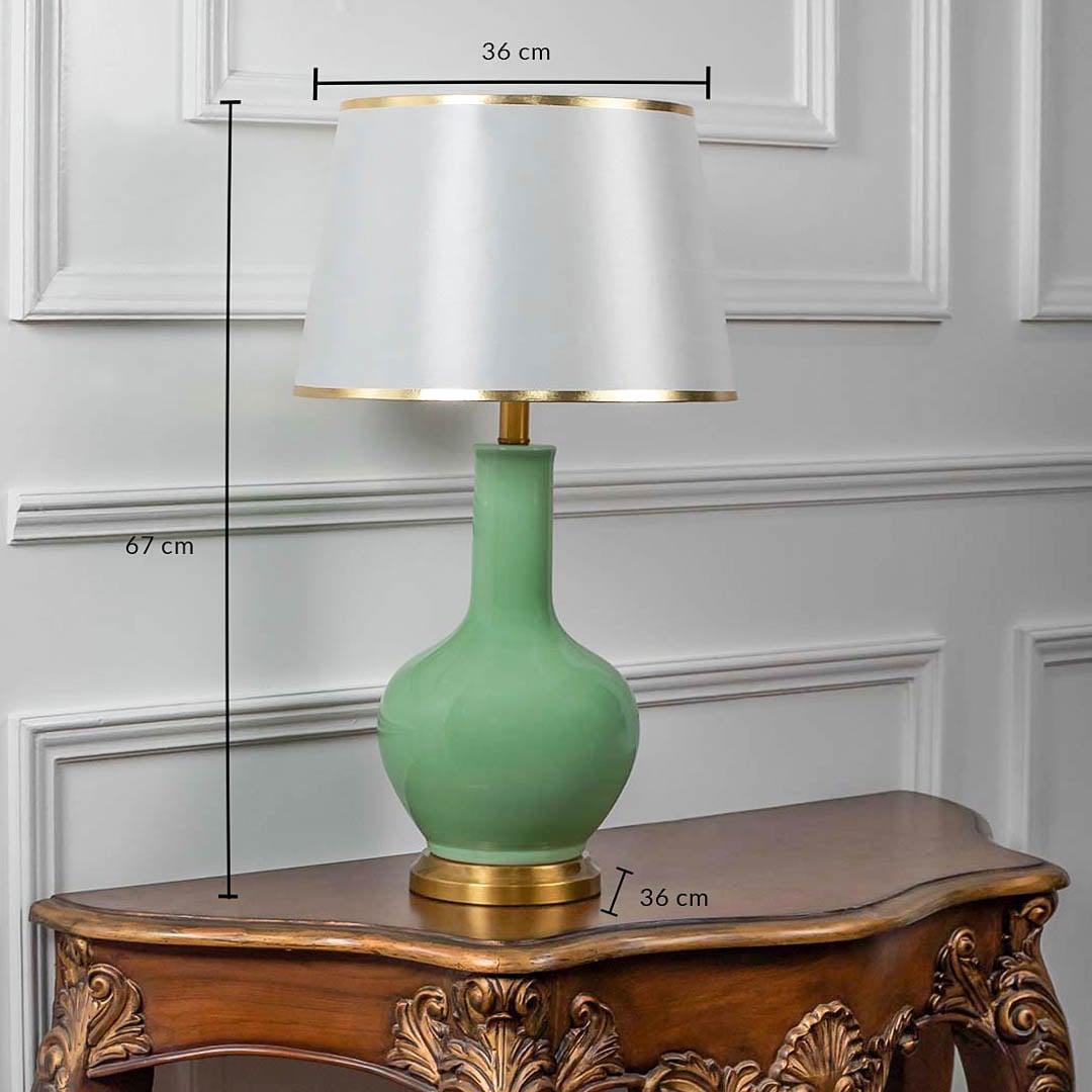 Green ceramic table lamp with fabric shade and golden base shown with 67cm height and 36cm width.