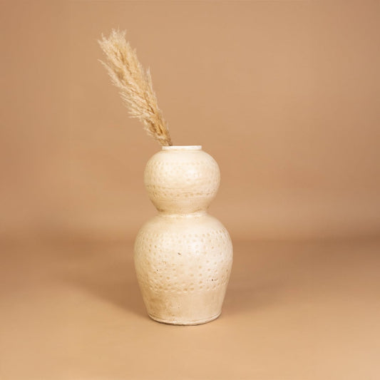 Beige textured decorative vase styled in a warm modern room adding earthy sculptural decor to living rooms hallways and contemporary interior spaces.