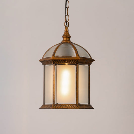 Decorative hanging lantern light turned on against a white background with a warm glow highlighting its antique frame and frosted glass panels.