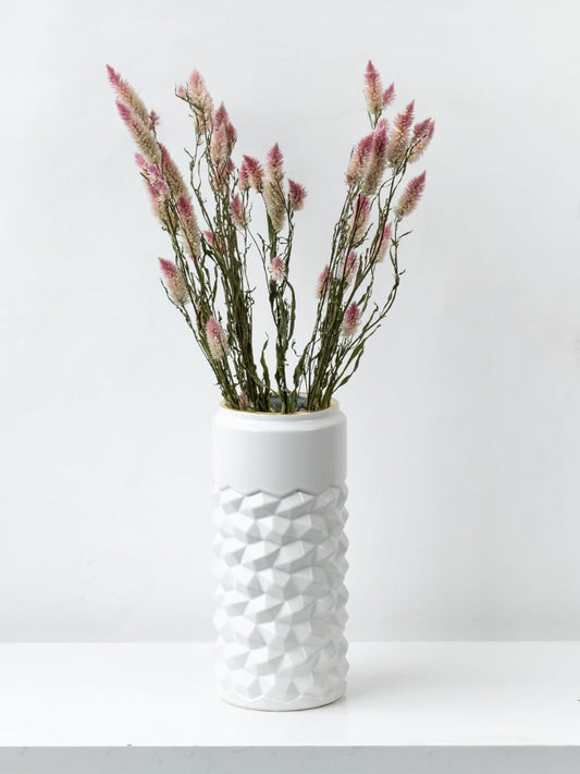 Modern white ceramic vase with raised geometric texture placed in a bright lifestyle setup enhancing the decor with a stylish touch.