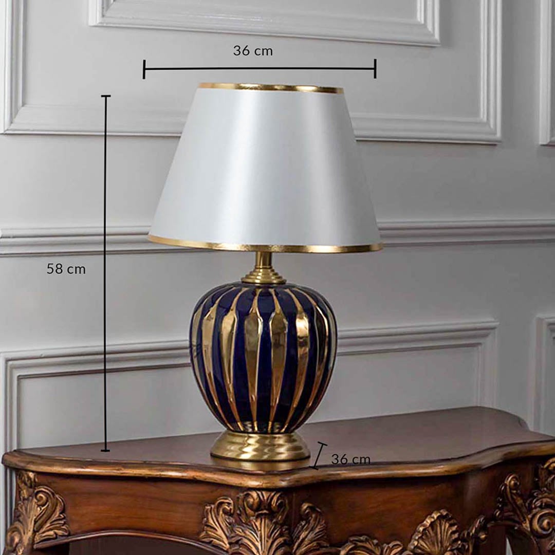 Blue ceramic table lamp with gold striped base and lampshade shown with 58cm height and 36cm width dimensions.