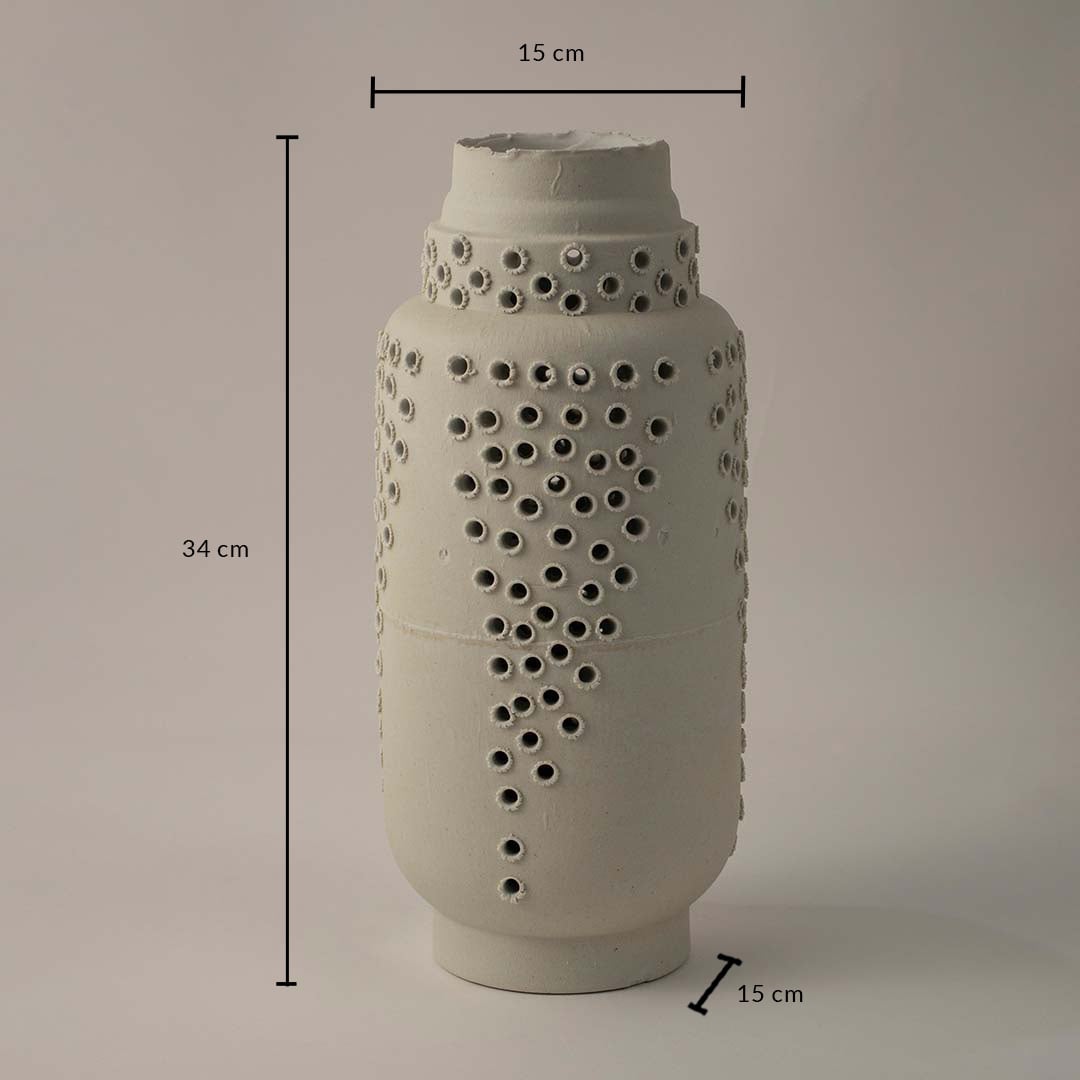 White ceramic perforated vase with artistic detailing shown with 34 cm height and 15 cm diameter for contemporary interiors.