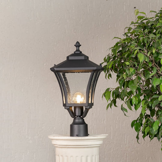 Light on pillar light in black metal with clear glass panels ideal for outdoor entrances showcasing warm glow on white background.