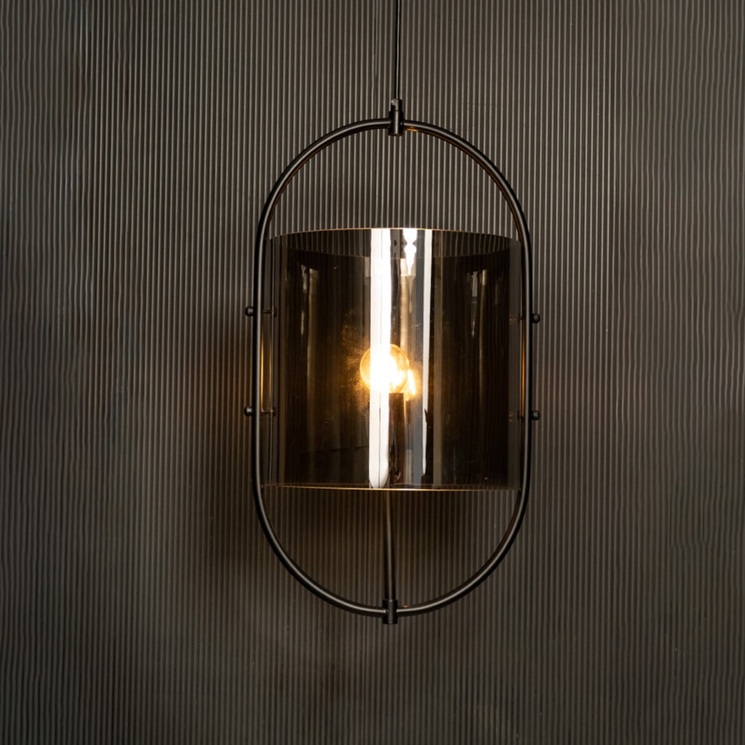 Illuminated pendant showcasing a striking contrast between the black metal frame and smoked glass against a dark backdrop.