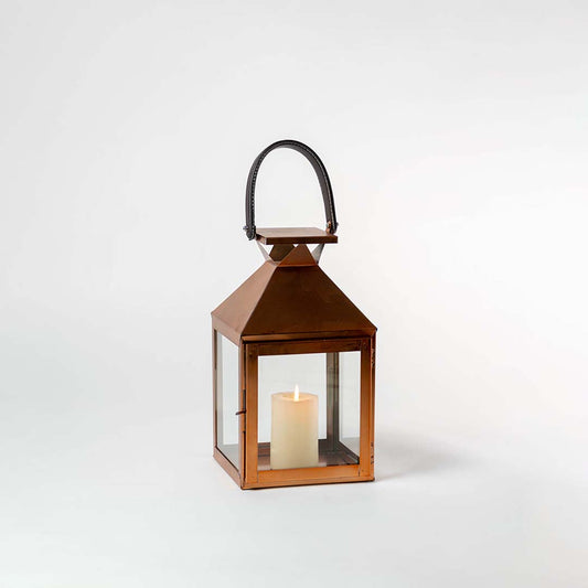 Outdoor metal lantern with warm candle light on white background featuring classic design ideal for patio balcony decor.