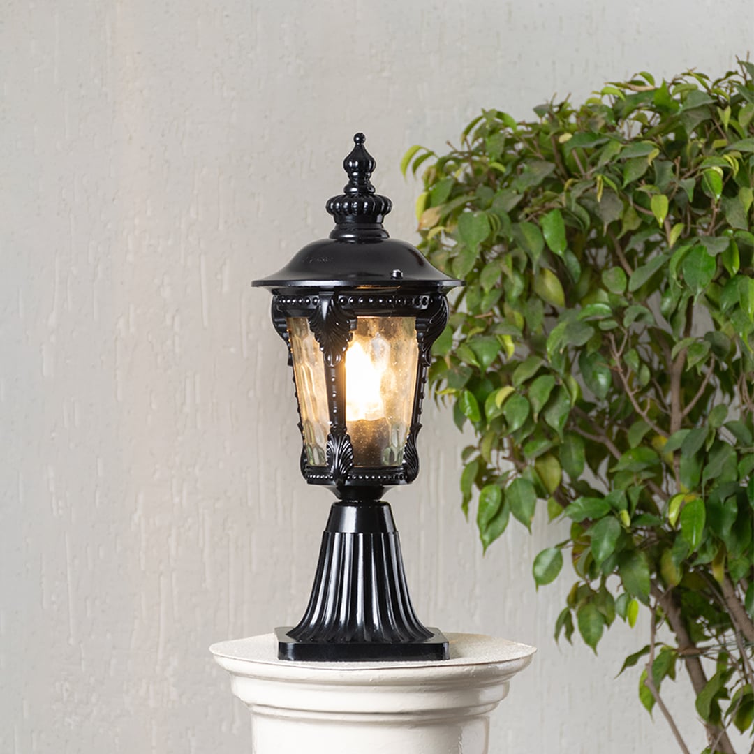 Black pillar light with decorative patterned glass displayed on white background highlighting elegant classic outdoor design.