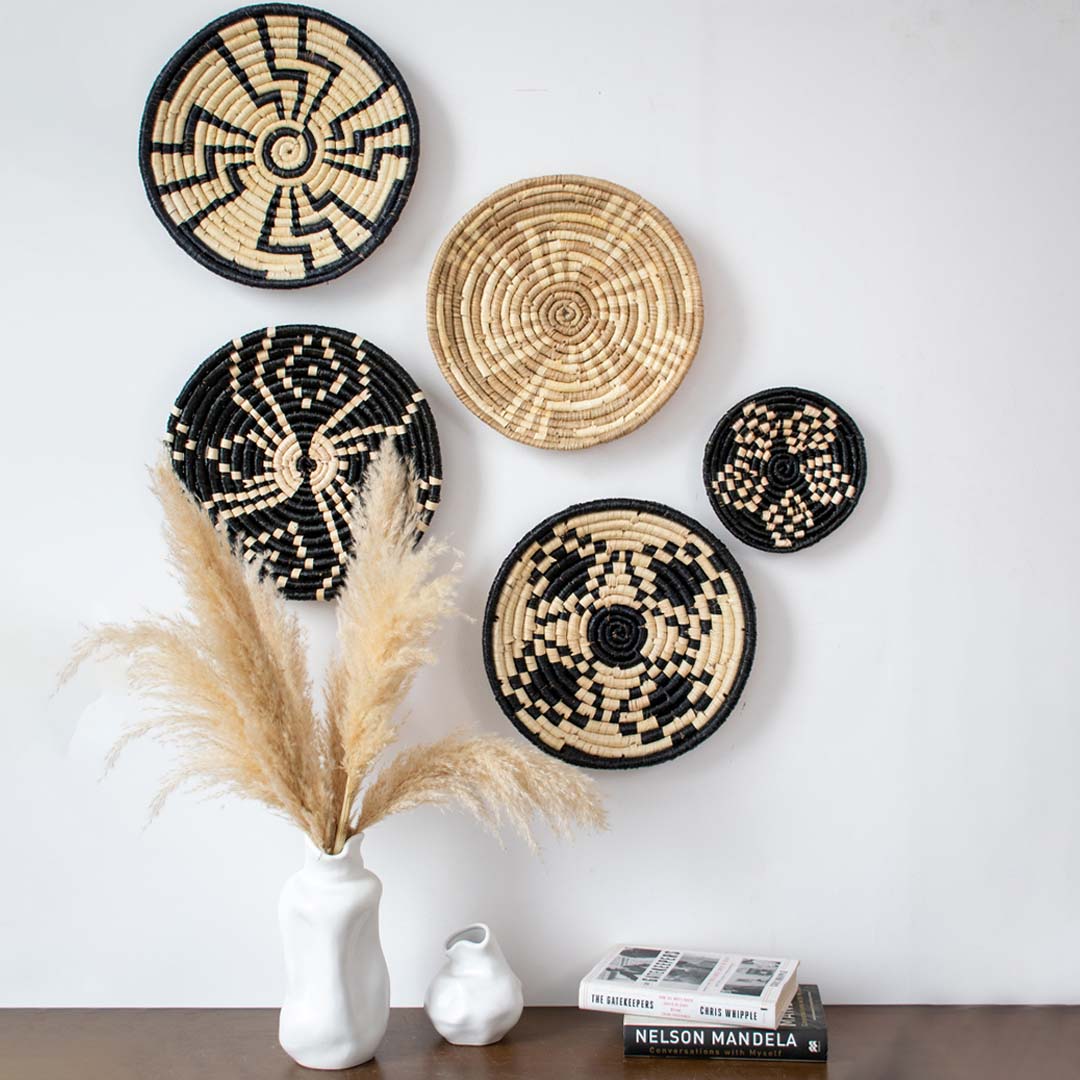 Handcrafted woven wall basket displayed above console table with vases and books – bohemian home wall decor accent.