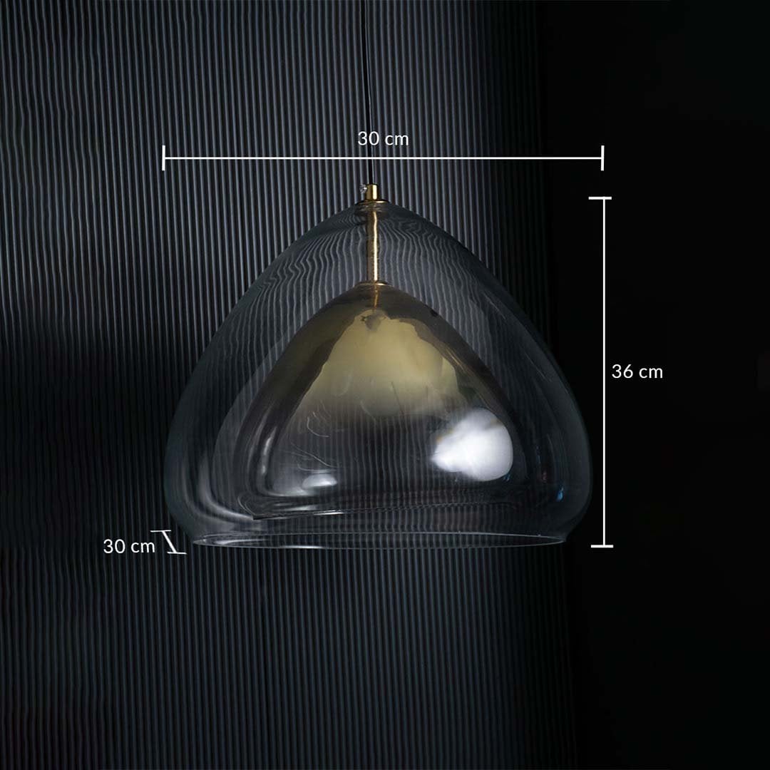 Glass pendant light with transparent curved shade and gold interior displayed against a dark striped background showing dimensions of 30 cm width 36 cm height and 30 cm depth.