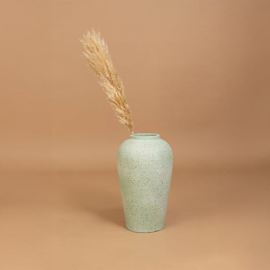 Tall light grey terracotta vase styled in a warm interior adding soft handcrafted texture and natural earthy elegance to contemporary home decor styling.