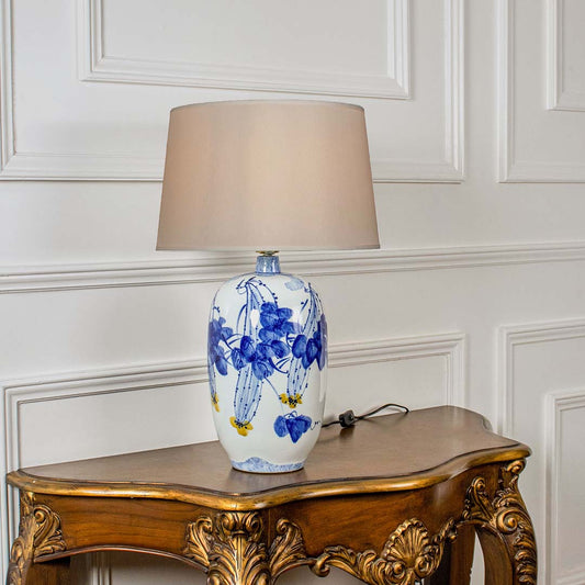Blue floral ceramic table lamp with fabric shade crafted for elegant traditional decor and ambient table lighting indoors.