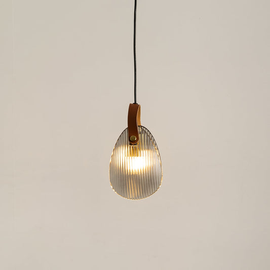 Ribbed glass pendant light with leather strap glowing on a white background for modern hanging lighting decor.