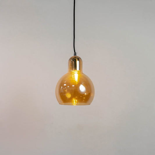 Amber glass and brass metal pendant light with warm glow for elegant contemporary home decor spaces.