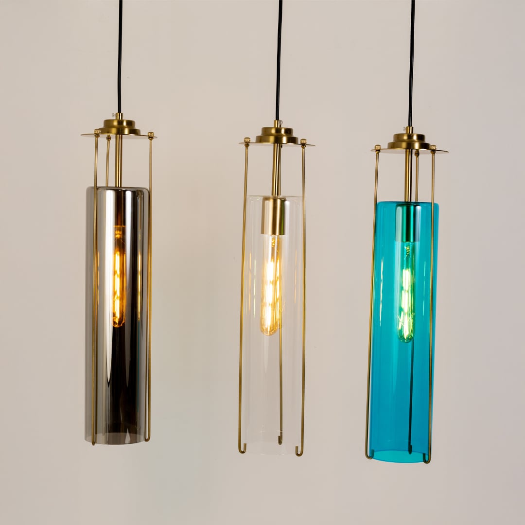 Modern smoked glass pendant light shown in a grouped view with brass detailing and a tall cylinder design for a stylish contemporary display.