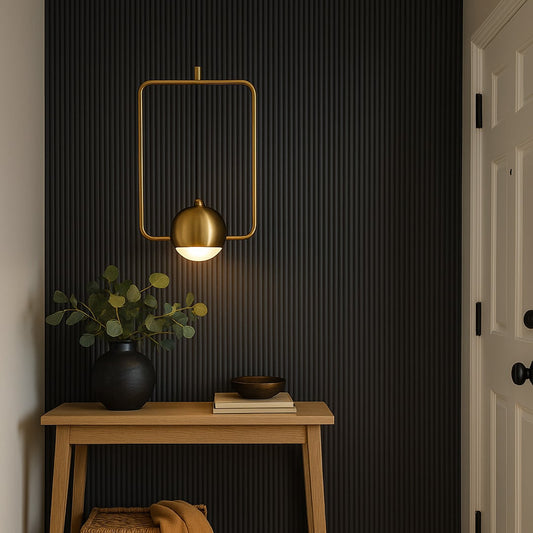 Modern brass gold wall lamp with metal frame and globe shade adding luxury accent lighting to hallway and living interiors.