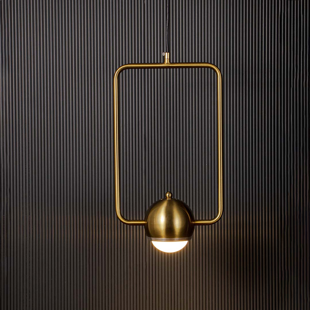 Brass gold wall lamp with frosted globe shade glowing softly against dark background creating a luxurious modern ambience.