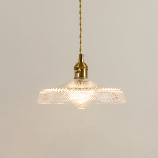 Illuminated clear glass pendant light with gold chain creating soft ambient lighting for stylish interiors.