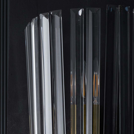 Detailed macro view of clear ribbed glass panels on a modern luxury wall sconce fixture set against a dark backdrop.