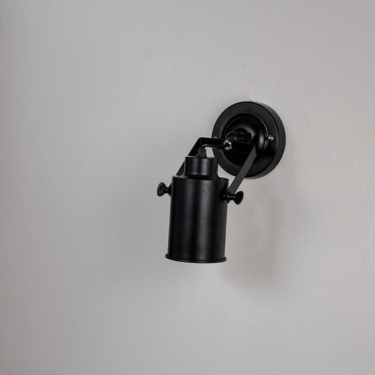 Black metal spotlight wall light with adjustable cylindrical shade shown off on white background for modern industrial decor.
