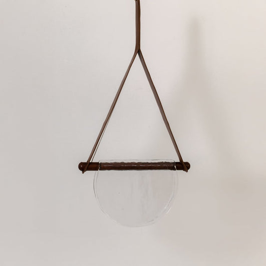 Pendant light with clear half-moon textured glass shade shown turned off against a white background highlighting its simple elegant design.