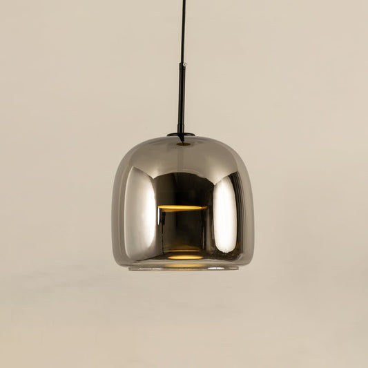 Metallic pendant light with a smooth rounded reflective shade hanging elegantly and producing a warm bright glow that adds a sleek contemporary accent to the room.