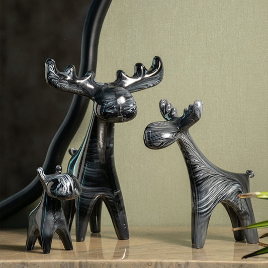 Black marble textured moose figurines styled on console table for elegant modern home interiors and decoration.