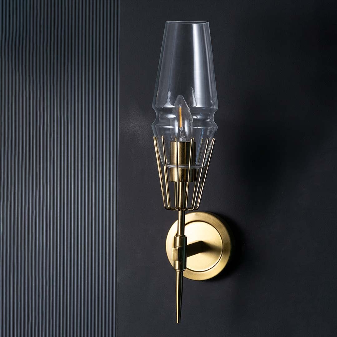 Sleek unlit wall lamp with brass cage detail and clear glass shade shown on black background showcasing premium metal finish and quality.