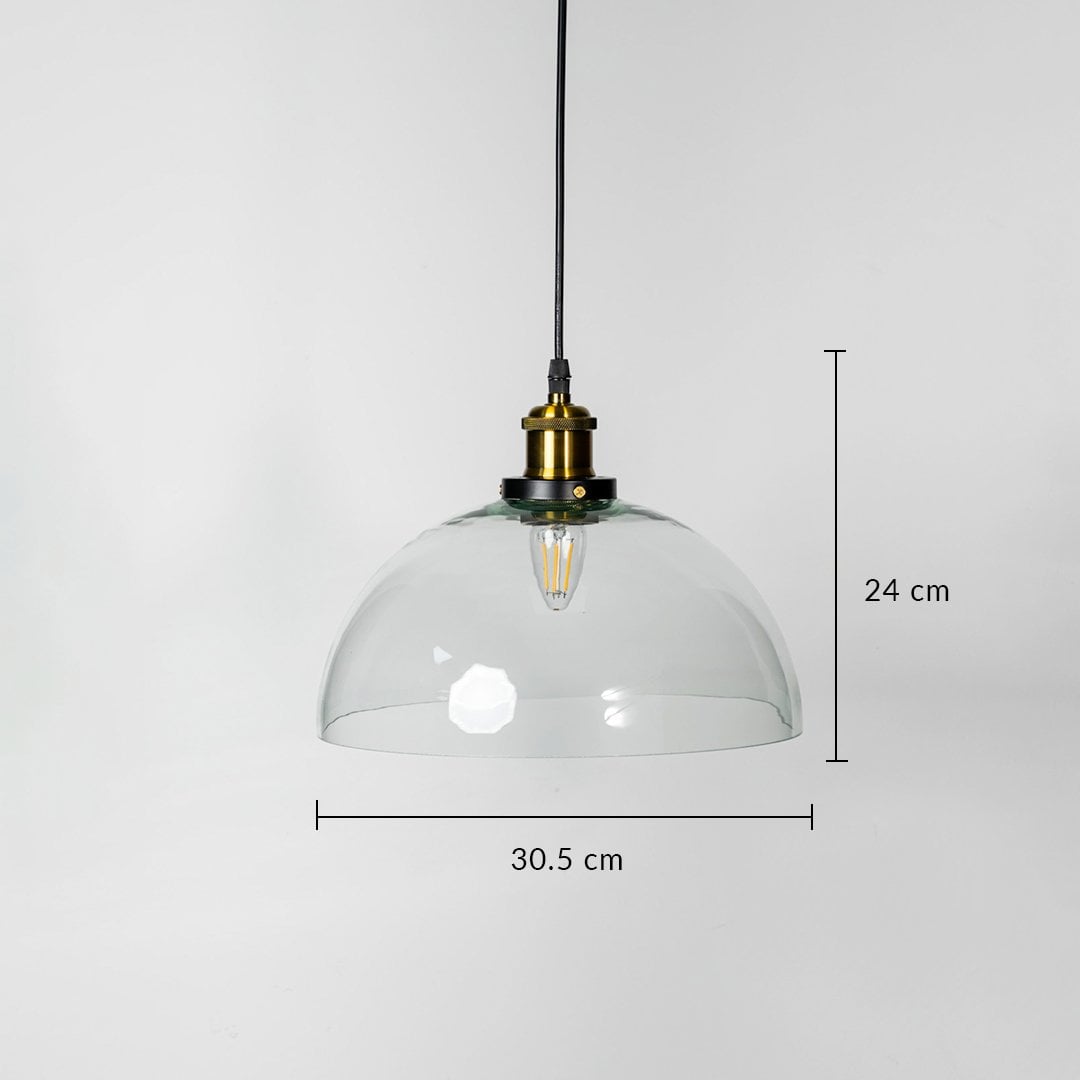 Dome pendant light with clear glass shade brass fitting and black cord shown with 24cm height and 30.5cm width.