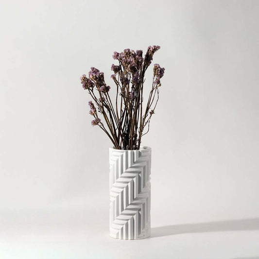 Soft purple dried flowers held in hand against a warm room setting adding rustic natural charm to modern home decor.