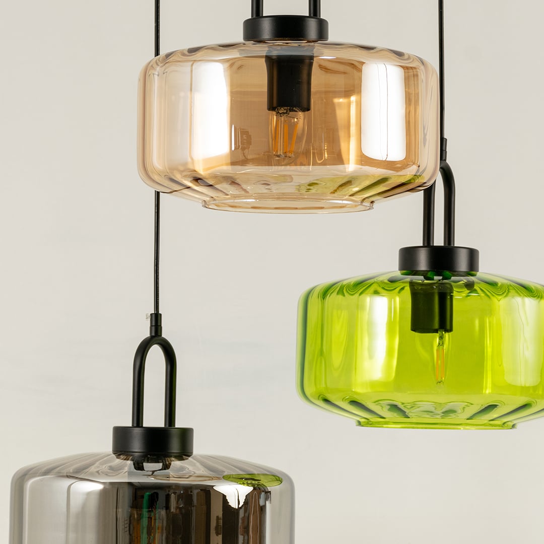Amber smoke and green glass pendant lights creating vibrant ambient lighting in a stylish contemporary interior setting.