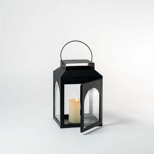 Elegant black lantern showcased on a white background with bright lighting emphasizing its metal frame.