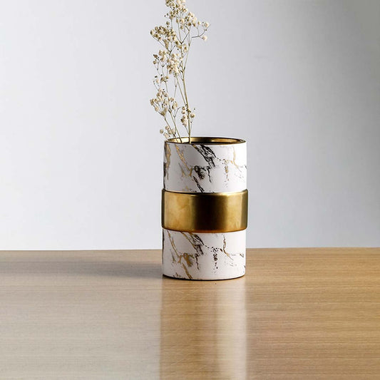 White marble finish metal candle holder with gold accent placed on wooden table adding modern luxury touch to home Decor.