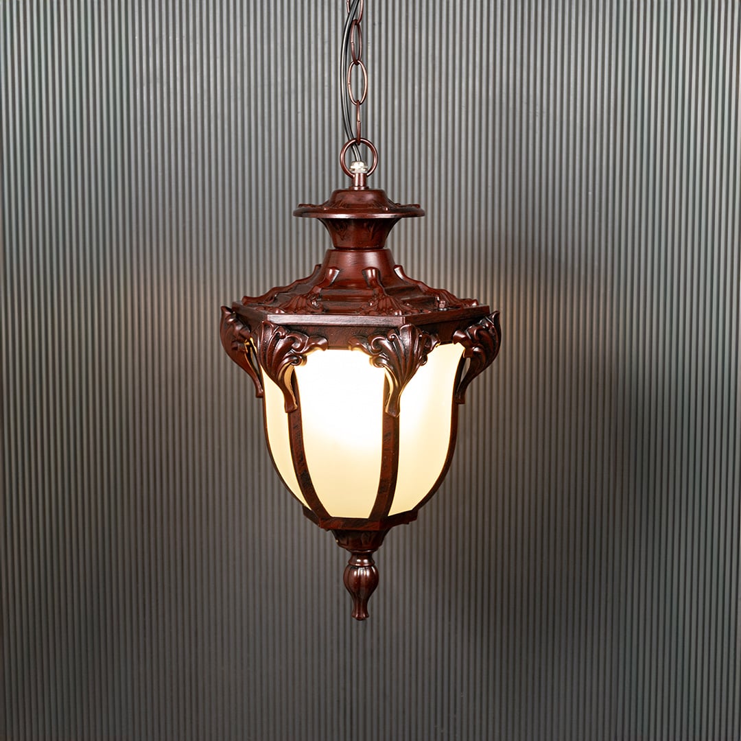 Brown hanging lantern with frosted glass glowing warmly on black background creating a classic outdoor ambience.