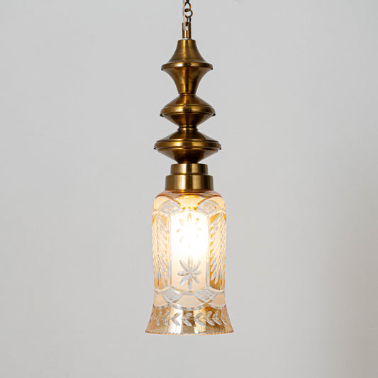 Decorative pendant light in gold metal finish with textured glass shade for dining room or living decor lighting white background.