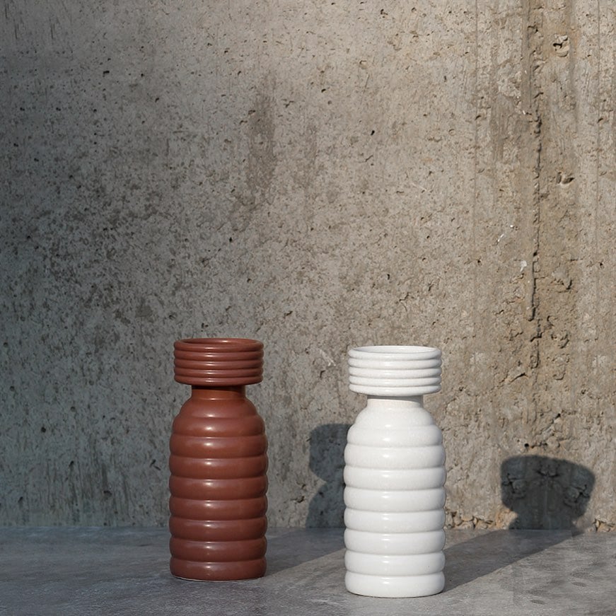 Grouped image showcasing the ribbed white ceramic vase in a clean minimal setup highlighting its modern shape and textured design.