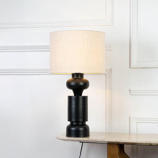 Classic table lamp in black base with fabric shade for bedside or living room decor lighting placement white background.