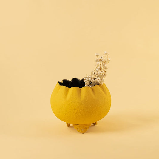 Yellow metal scalloped bowl planter decor placed in a warm modern setting adding a bright stylish accent to living room spaces.