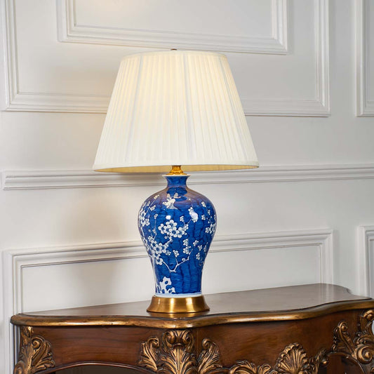 Blue floral ceramic table lamp with fabric shade designed for timeless traditional decor and ambient table lighting indoors.