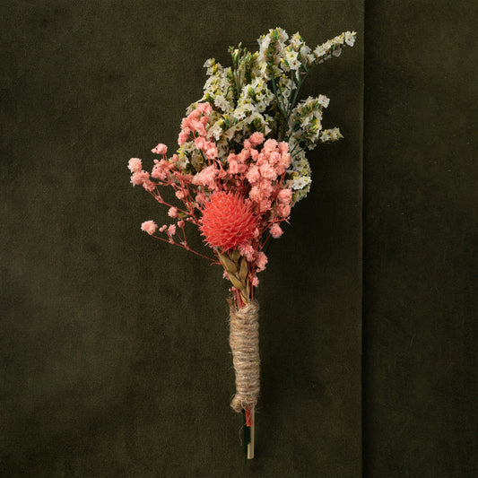 Artificial dried flower boutonniere with pink blooms natural grass and greenery for wedding groom lapel floral accessory.