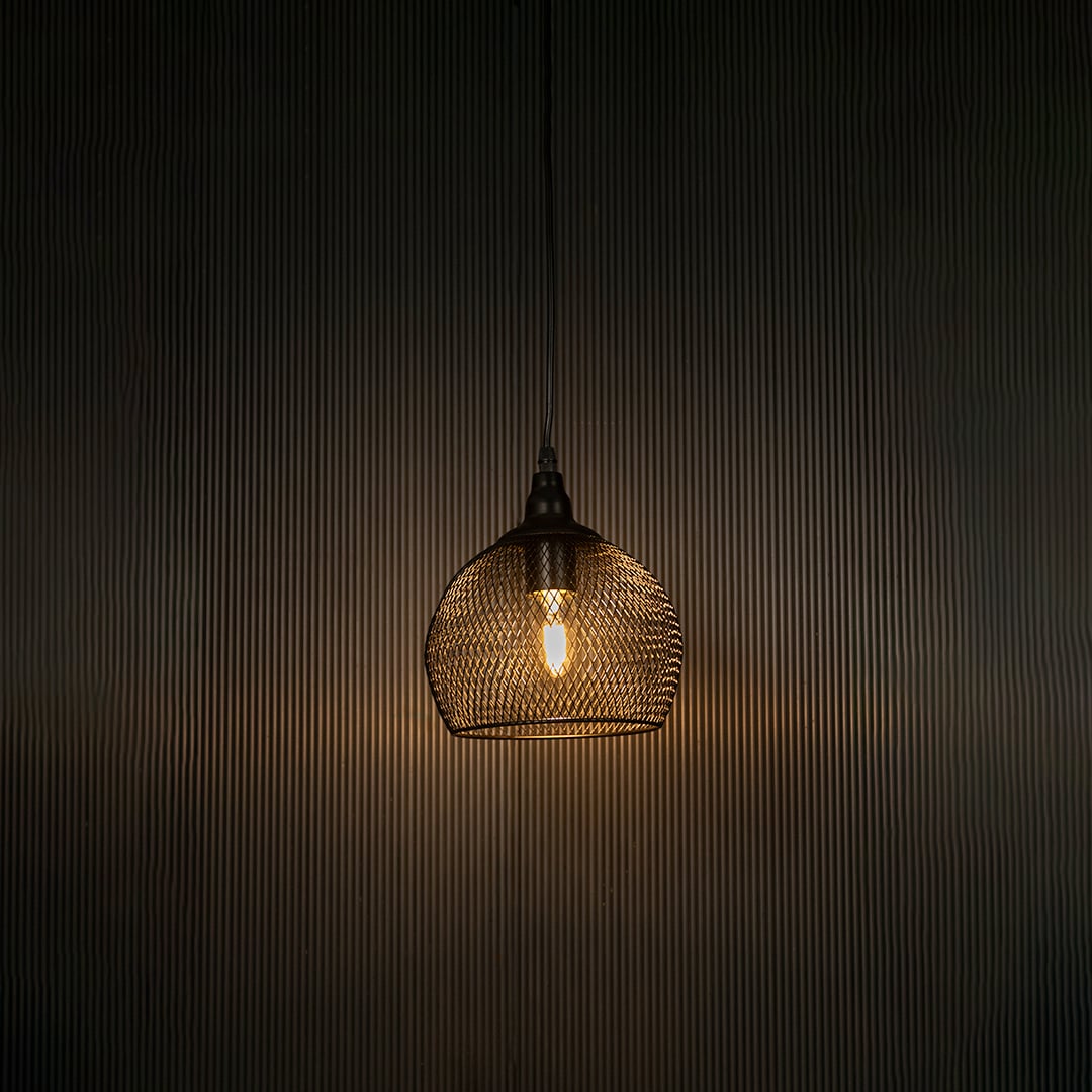 Black mesh pendant light illuminated beautifully against dark background highlighting sleek craftsmanship.