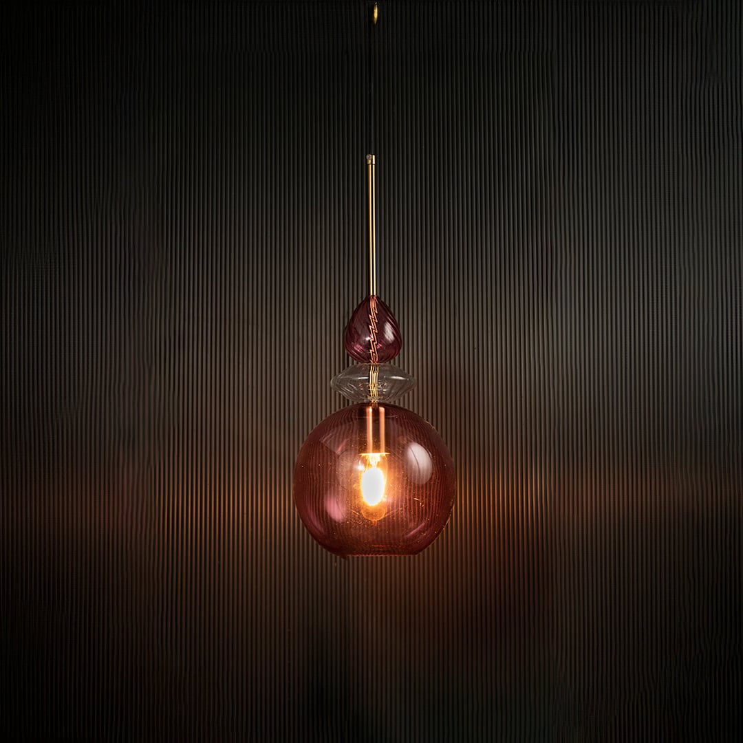 Light off decorative rose pink hanging light with gold accents mounted on a dark ceiling.