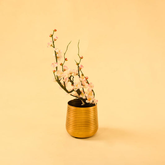 Gold metal planter decor styled in a warm modern room adding a bright elegant accent to living room tables and shelves.