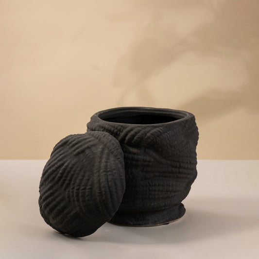 Black ceramic decorative sculpture with wrapped texture design for modern tabletop styling and artistic home decor.